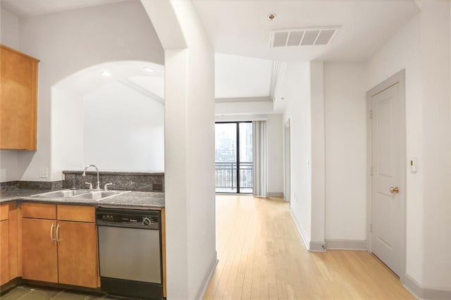 kitchen featuring visible vents, light wood-style flooring, stainless steel dishwasher, brown cabinetry, and a sink