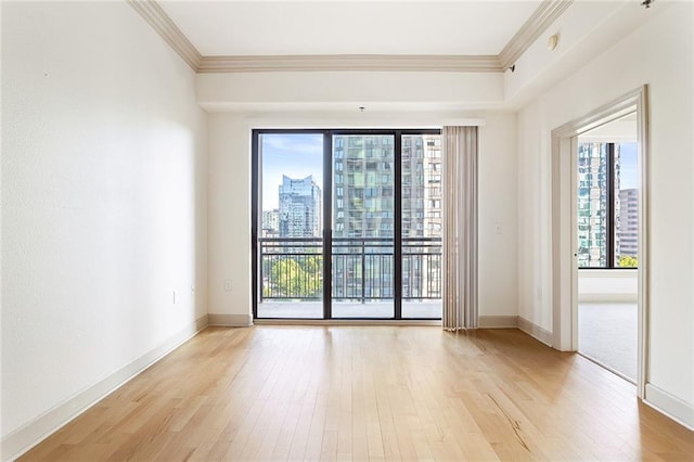 3445 Stratford Rd NE Unit 1605, Atlanta, GA 30326 - empty room with crown molding, light wood-type flooring, baseboards, and a city view