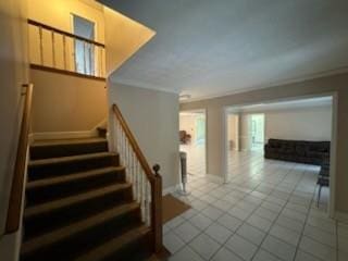 stairway featuring tile patterned flooring and crown molding