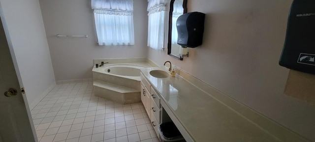 bathroom featuring a relaxing tiled tub, vanity, and tile patterned floors