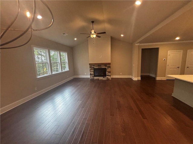 unfurnished living room with dark wood-type flooring, vaulted ceiling, ceiling fan, and a fireplace