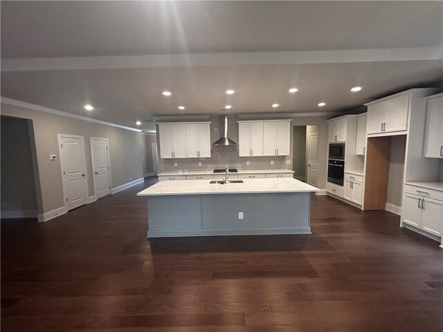 kitchen with dark hardwood / wood-style flooring, wall chimney exhaust hood, oven, a kitchen island with sink, and light stone countertops