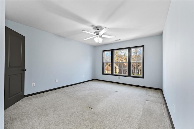 spare room with visible vents, carpet floors, a ceiling fan, and baseboards