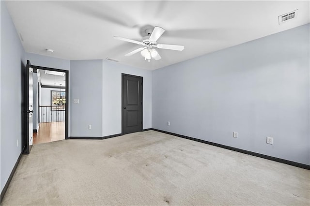 unfurnished bedroom with a ceiling fan, visible vents, light carpet, and baseboards