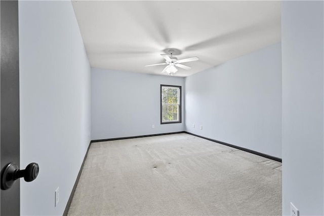 spare room featuring a ceiling fan, carpet, and baseboards