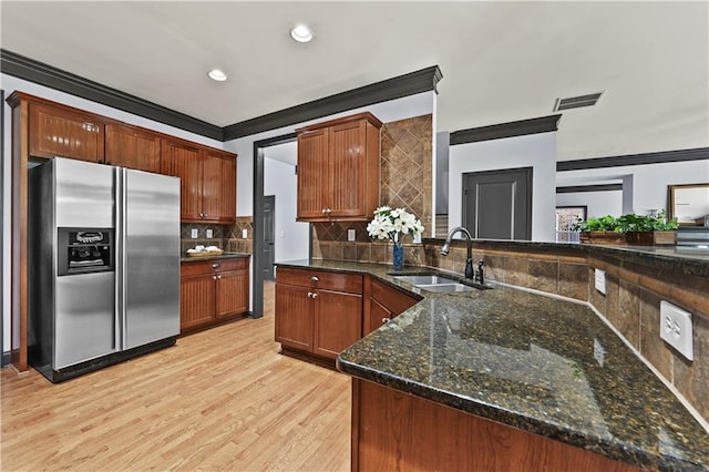 kitchen featuring crown molding, light wood-type flooring, a sink, and stainless steel refrigerator with ice dispenser