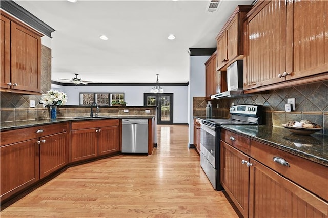 kitchen featuring visible vents, brown cabinetry, appliances with stainless steel finishes, light wood-type flooring, and a sink