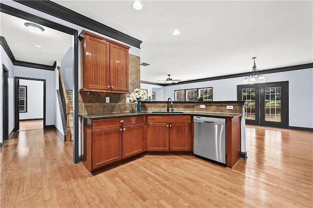 kitchen with crown molding, tasteful backsplash, a sink, dishwasher, and a peninsula