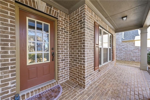 property entrance featuring brick siding and a porch