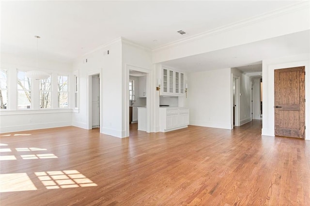 1585 S Ponce De Leon Ave NE Unit 20, Atlanta, GA 30307 - unfurnished living room with light wood finished floors, baseboards, and crown molding
