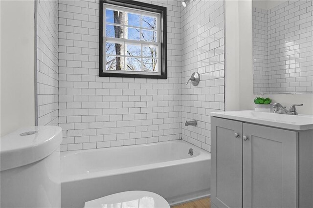 full bathroom with vanity, toilet, and tiled shower / bath combo