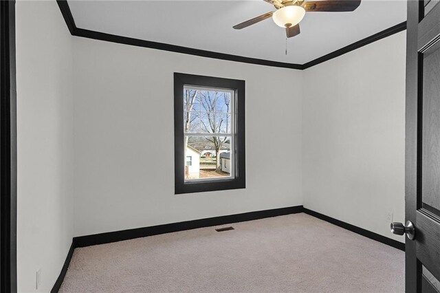 spare room featuring ceiling fan, light colored carpet, and ornamental molding