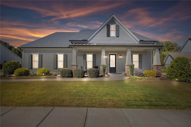 view of front of house featuring a yard and covered porch