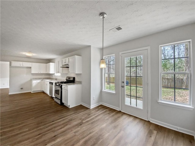 kitchen featuring sink, white cabinets, dark hardwood / wood-style flooring, pendant lighting, and appliances with stainless steel finishes