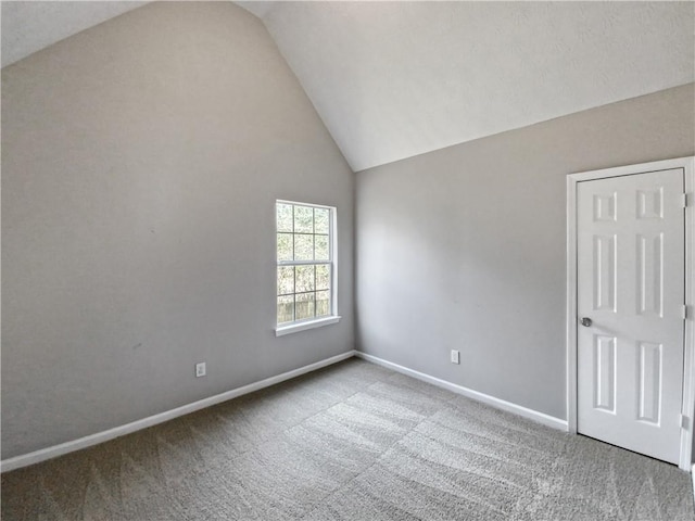 spare room with vaulted ceiling and carpet