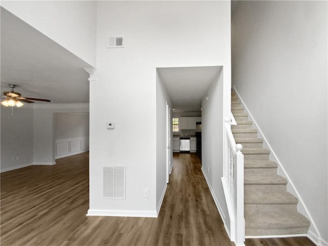 stairs featuring wood-type flooring and ceiling fan