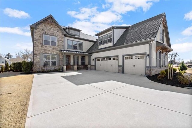 craftsman house featuring roof with shingles, brick siding, an attached garage, board and batten siding, and driveway