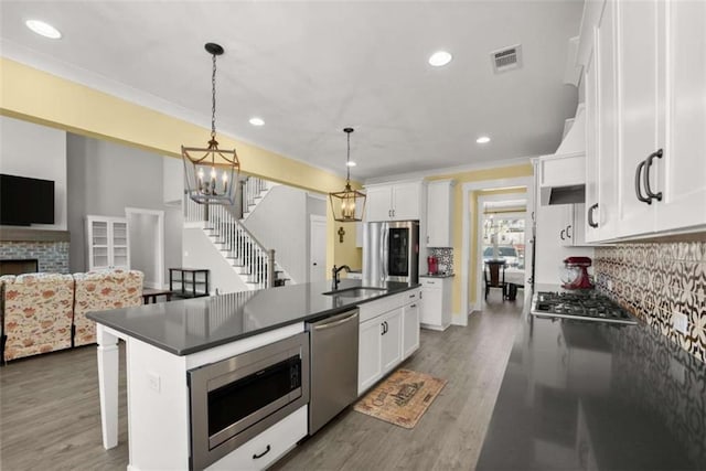 kitchen featuring dark countertops, visible vents, stainless steel appliances, and a sink