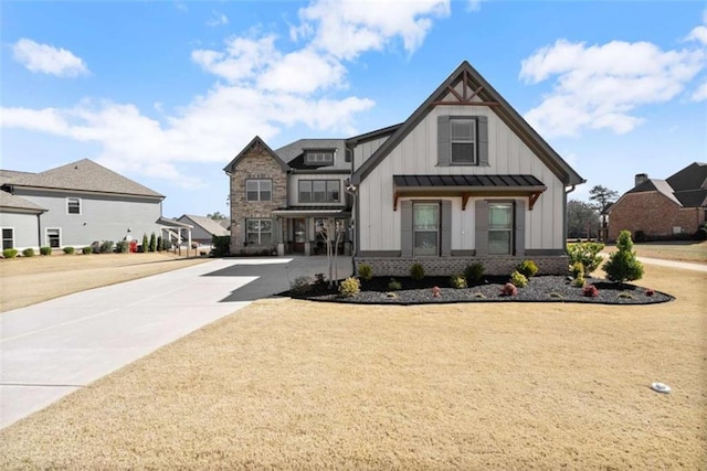 view of front of house with concrete driveway, metal roof, a standing seam roof, board and batten siding, and brick siding