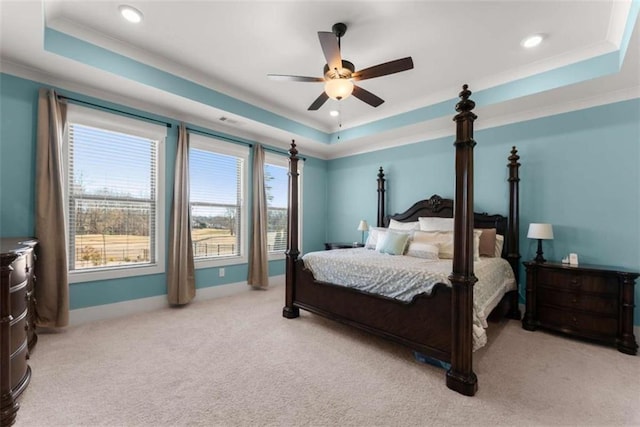 bedroom featuring a raised ceiling, light carpet, crown molding, and baseboards