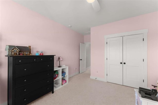 bedroom featuring ceiling fan, a closet, and light colored carpet