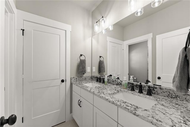 full bathroom with double vanity and a sink