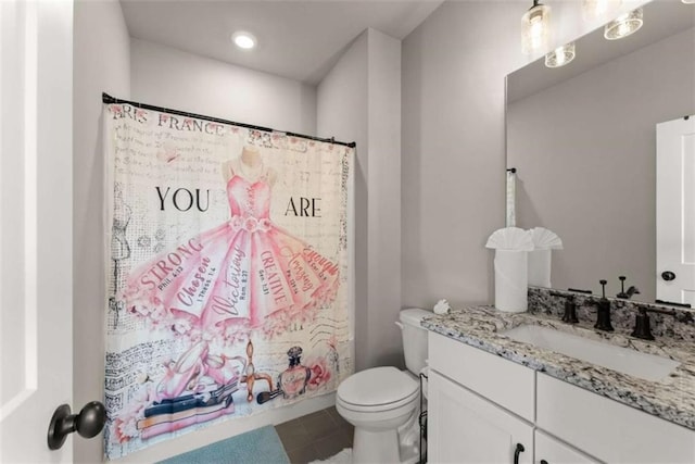 bathroom with toilet, tile patterned floors, and vanity