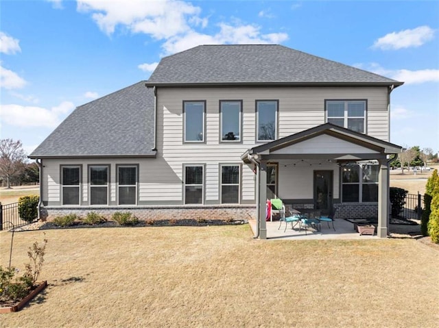 back of house with a shingled roof, a patio area, brick siding, and fence