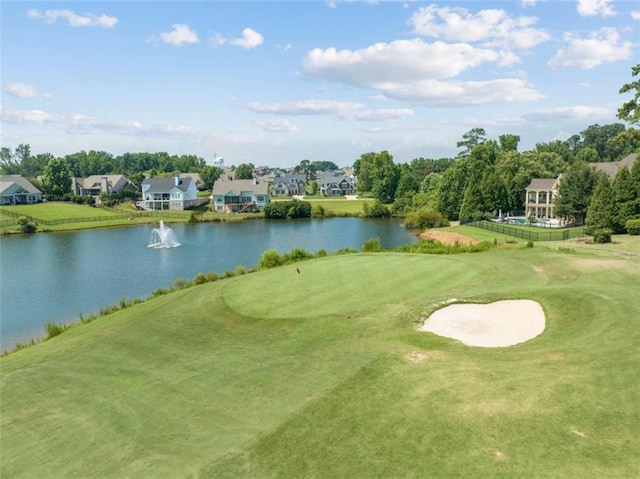 view of property's community with a lawn, a water view, and golf course view