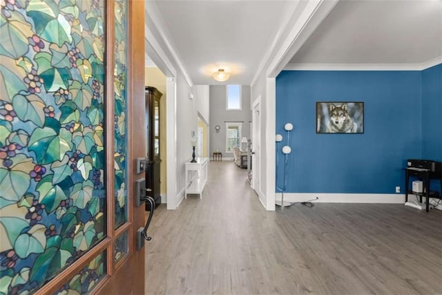 entryway with crown molding, baseboards, and wood finished floors