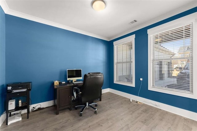 home office featuring baseboards, wood finished floors, visible vents, and crown molding