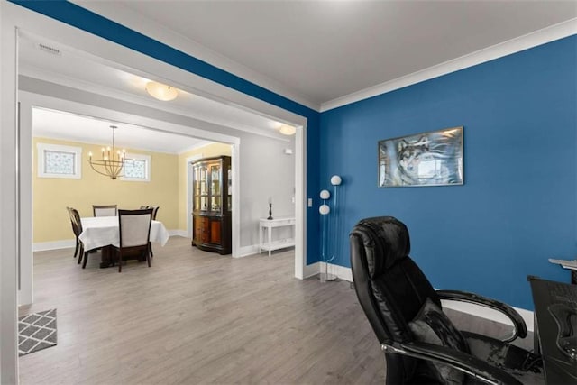 office area featuring a notable chandelier, wood finished floors, visible vents, baseboards, and ornamental molding