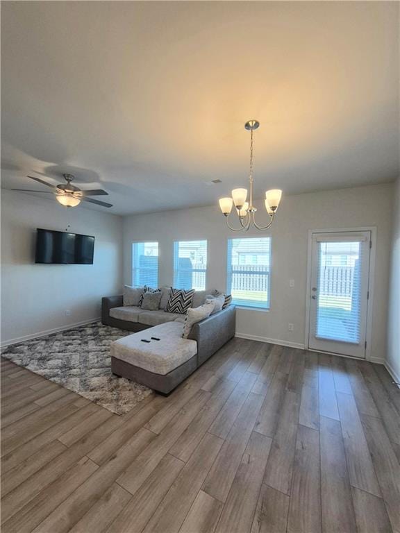 living room featuring light hardwood / wood-style floors and ceiling fan with notable chandelier