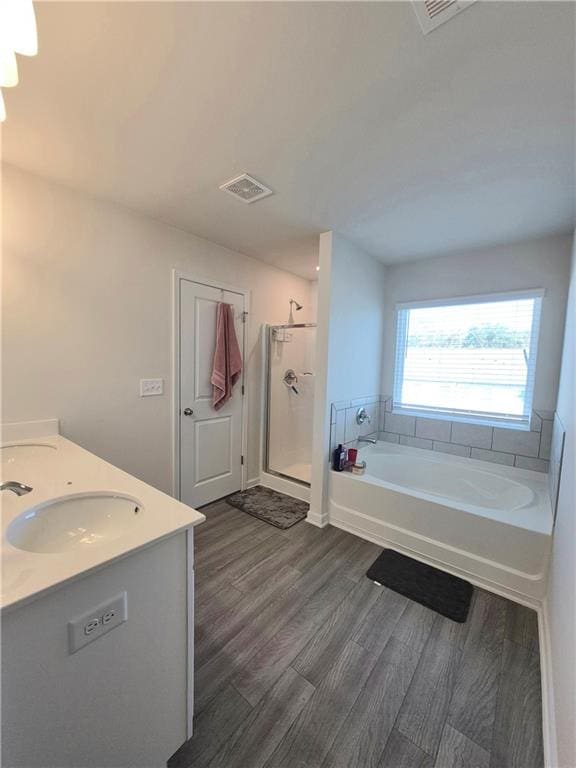 bathroom featuring vanity, plus walk in shower, and hardwood / wood-style flooring