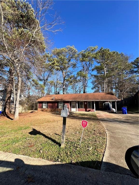 ranch-style home with a carport and a front yard