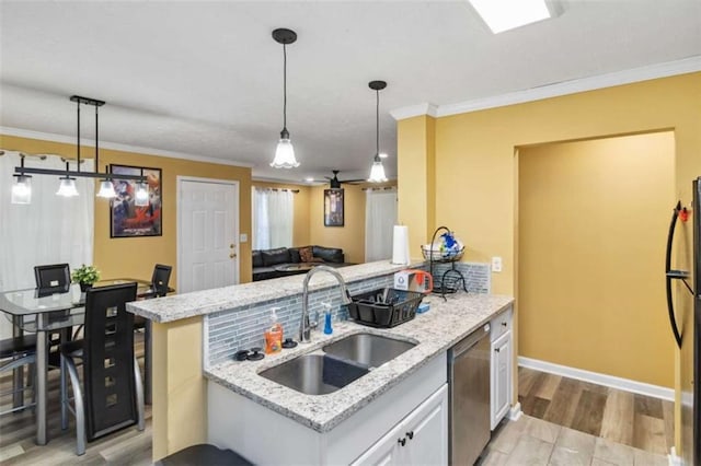 kitchen featuring ornamental molding, light wood-type flooring, appliances with stainless steel finishes, and a sink