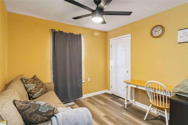 living area with visible vents, ceiling fan, baseboards, and wood finished floors