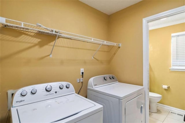 laundry room with visible vents, baseboards, light tile patterned floors, laundry area, and washer and dryer