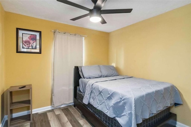 bedroom with baseboards, wood finished floors, and a ceiling fan