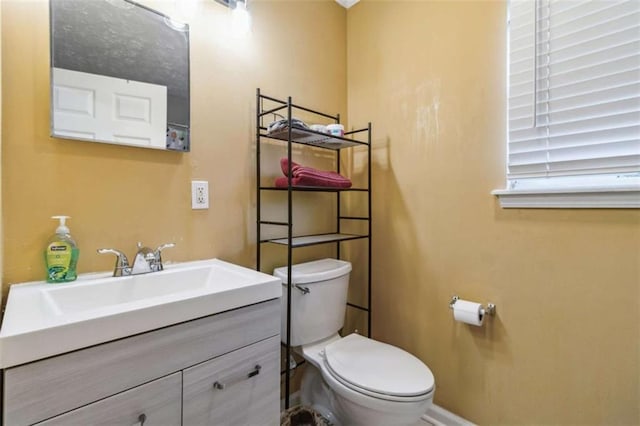 bathroom featuring vanity, toilet, and baseboards