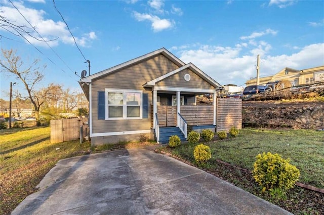 view of front of house featuring a porch, fence, and a front yard