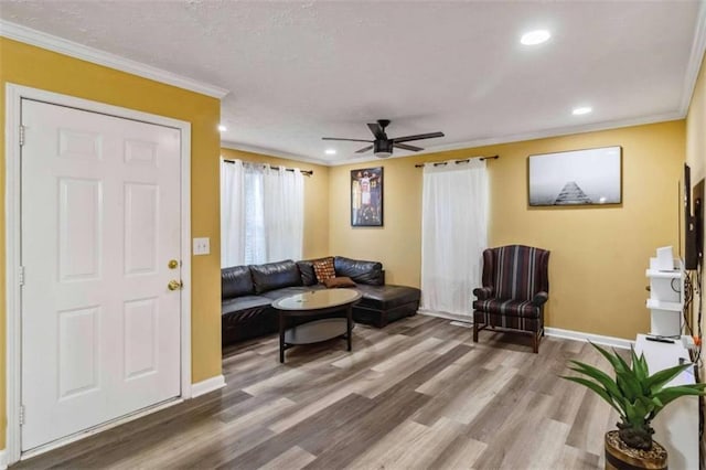 living area featuring recessed lighting, wood finished floors, baseboards, and ornamental molding