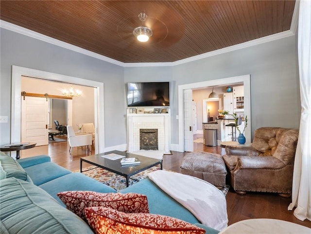 living room with a brick fireplace, ornamental molding, wood ceiling, a barn door, and hardwood / wood-style floors