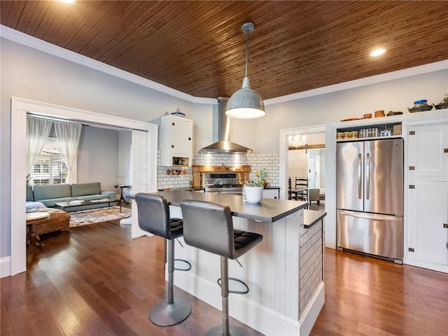 kitchen with stainless steel fridge, a breakfast bar, crown molding, pendant lighting, and white cabinetry