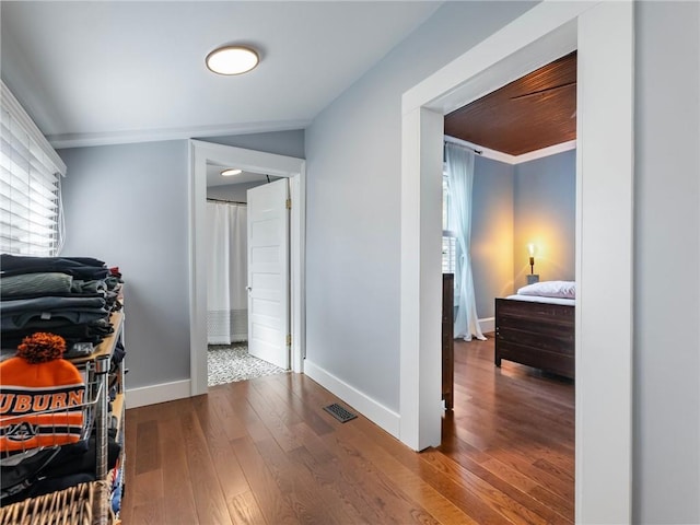 hall with hardwood / wood-style flooring and ornamental molding