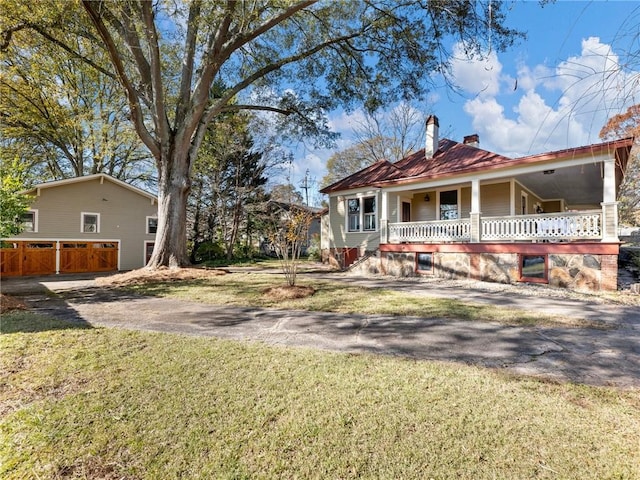 rear view of property with a yard and a porch