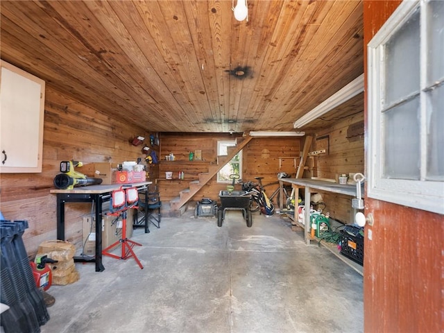 interior space featuring a workshop area, wood walls, concrete flooring, and wooden ceiling