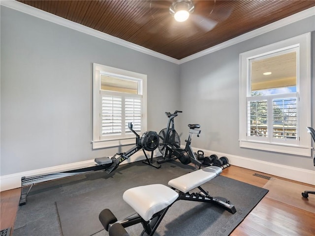 exercise room featuring hardwood / wood-style floors, ceiling fan, wooden ceiling, and crown molding