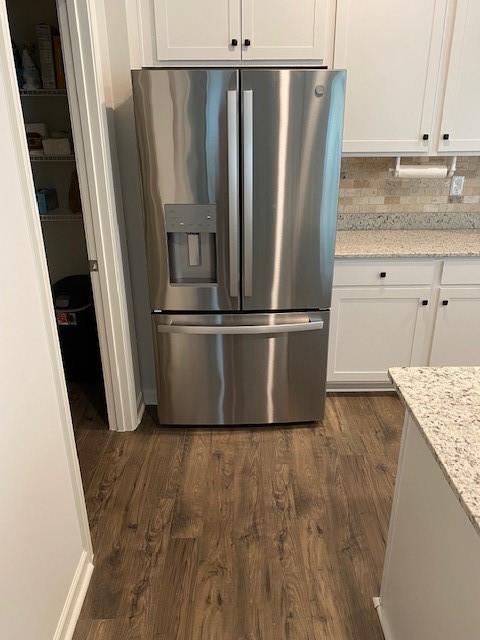 249 Creekview Way, Dallas, GA 30132 - kitchen featuring stainless steel refrigerator with ice dispenser, white cabinetry, dark wood-style floors, light stone counters, and backsplash
