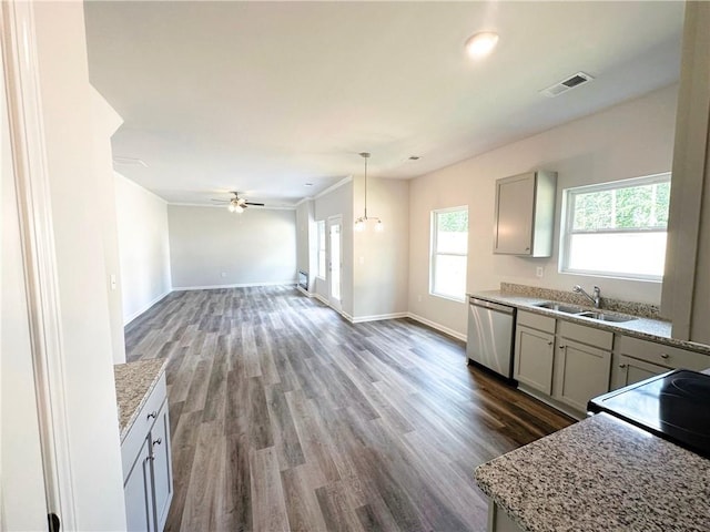 kitchen with visible vents, a sink, wood finished floors, dishwasher, and baseboards